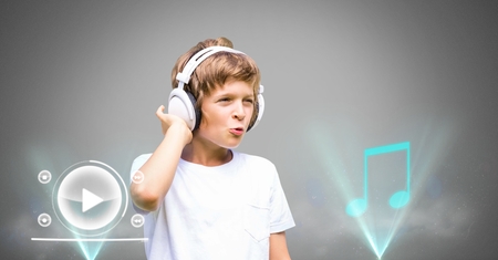 Digital composite of Boy against grey background with headphones and music player iconsの写真素材