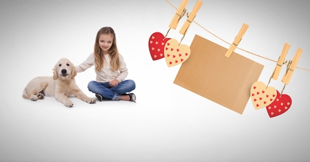 Digital composite of Girl and pet dog with hearts and blank note on pegsの写真素材