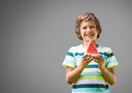 Digital composite of Boy against grey background with watermelonの写真素材