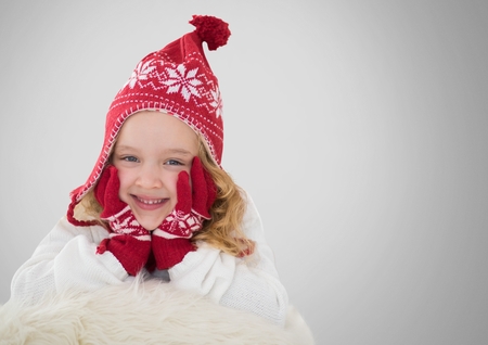 Digital composite of Girl against grey background with warm Christmas Winter hat and glovesの写真素材