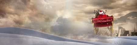 Digital composite of Cloudy sky and snow landscape city transition of Santa's sleigh and reindeer'sの写真素材