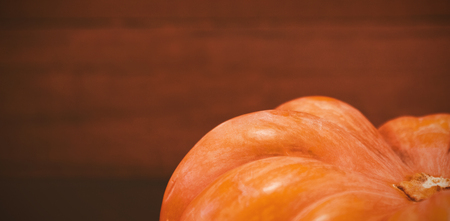 Cropped image of pumpkin against wooden plank during Halloweenの写真素材