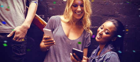 Flying colours against smiling woman with friend using mobile phone