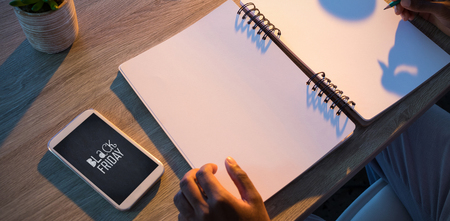 Cropped hands of male executive writing in diary at deskの写真素材