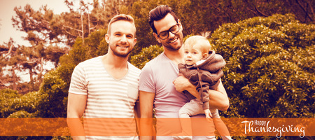 Illustration of happy thanksgiving day text greeting against happy gay couple with childの写真素材