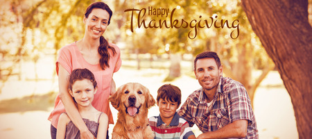 Illustration of happy thanksgiving day text greeting against portrait of happy family with dog in parkの写真素材