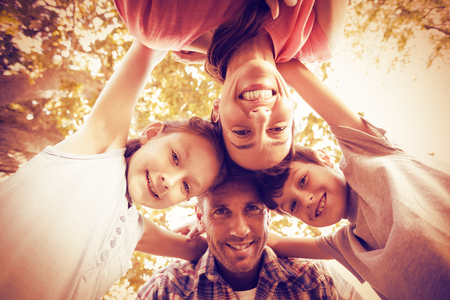 Portrait of happy family in park huddling in circleの写真素材