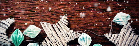 Snow falling against christmas light with star decoration at table