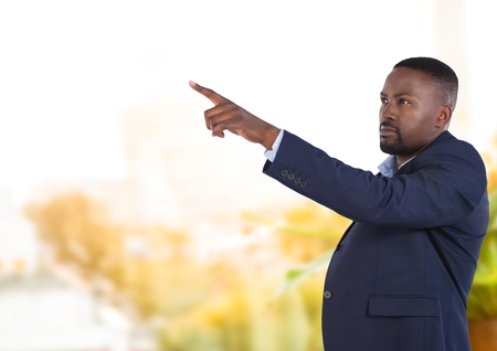 Digital composite of Businessman pointing touching air in front of greeneryの写真素材