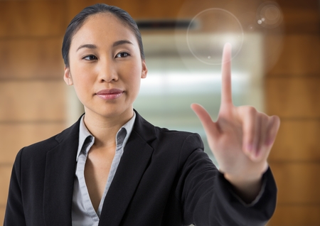 Digital composite of Businesswoman touching air in front of liftの写真素材