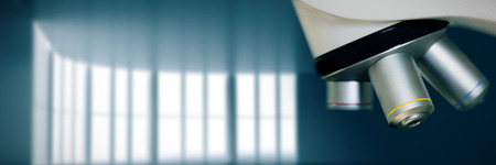 Close up on microscope in laboratory against abstract room