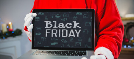 Black friday advert against santa claus holding a laptopの写真素材