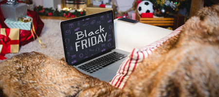 Black friday advert against laptop and mobile phone kept on sofaの写真素材