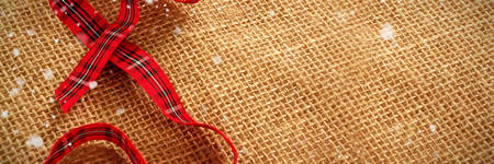 Snow falling against close up of red ribbonの写真素材