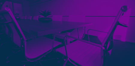 Empty chairs by conference table at modern officeの写真素材