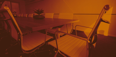 Empty chairs by conference table at modern officeの写真素材