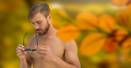 Digital composite of Nude man in forest with leaves and sunglassesの写真素材