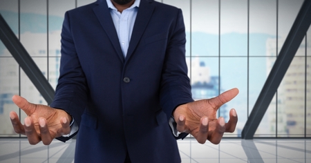 Digital composite of Businessman with hands palm open in city officeの写真素材