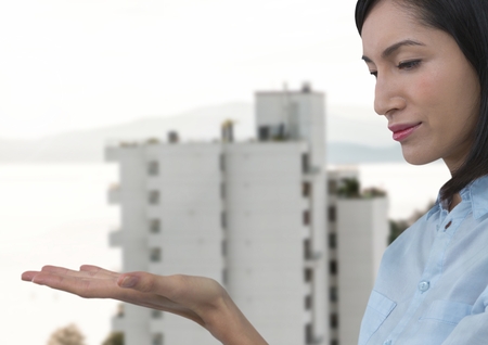 Digital composite of Businesswoman with hand palm open in cityの写真素材