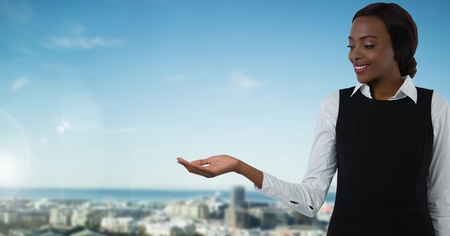 Digital composite of Businesswoman with hands palm open in cityの写真素材