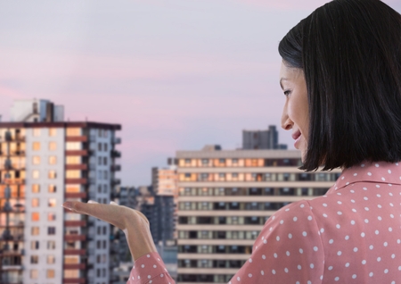 Digital composite of Businesswoman with hands palm open in cityの写真素材
