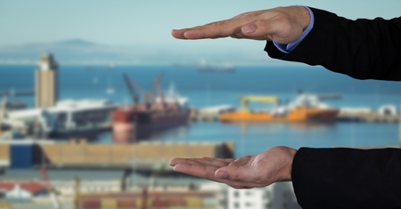 Digital composite of Businessman with hands palm open in city port harborの写真素材
