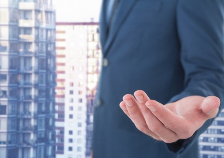 Digital composite of Businessman with hand palm open in city officeの写真素材