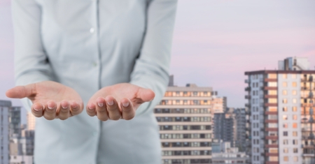 Digital composite of Business person with hands palm open in cityの写真素材