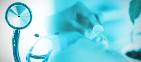 Blue stethoscope  against doctor experimenting with leafの写真素材