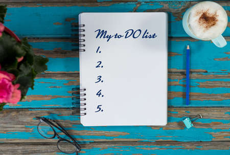 To do list from 1 to 5 against coffee with notepad and flower vaseの写真素材