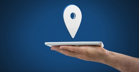 Digital composite of Hand holding tablet with 3D location marker pointer icon