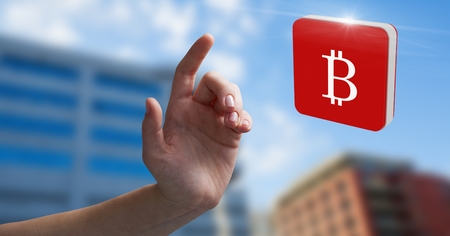 Digital composite of Hand touching bitcoin symbol iconの写真素材