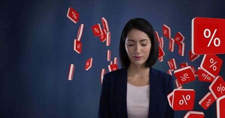 Digital composite of Percent icon symbols and Businesswoman with eyes closed and dark backgroundの写真素材