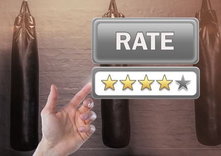 Digital composite of Hand touching Rate button and review stars in boxing gymの写真素材