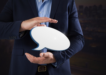 Digital composite of Chat bubble and Businessman with hands palm open and dark background