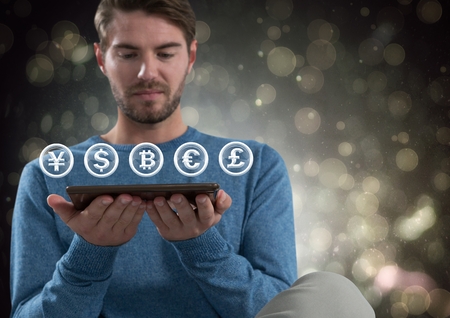 Digital composite of Currency icons and man holding tabletの写真素材