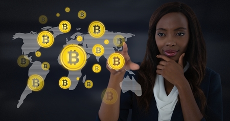 Digital composite of Businesswoman touching bitcoin graphic icons on world mapの写真素材