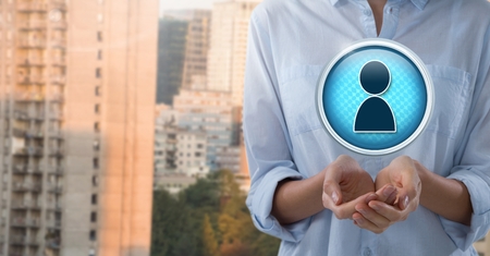 Digital composite of Profile contact icon and Businesswoman with hands palm open in cityの写真素材