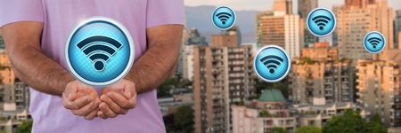 Digital composite of Wi-Fi icons and man with hands palm open in cityの写真素材