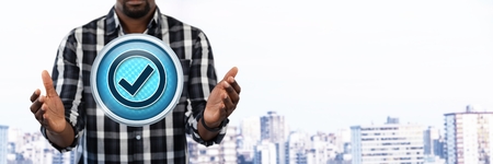 Digital composite of Correct tick mark and Businessman with hands palm open in cityの写真素材