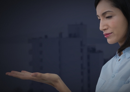 Digital composite of businesswoman with hands palm open and dark backgroundの写真素材