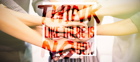 Think like there is no box  against close up of colleagues stacking handsの写真素材