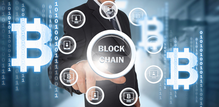 Symbol of bitcoin digital cryptocurrency with various icons against businessman using digital screenの写真素材