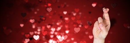 Digital composite of Valentine's fingers love couple and sparkling light heartsの写真素材