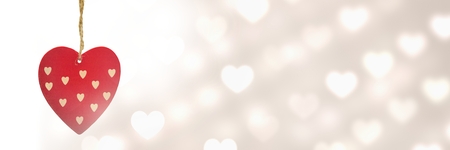 Digital composite of Valentines hanging heart and love hearts backgroundの写真素材