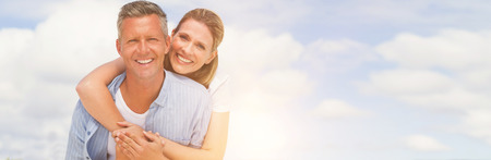 Portrait of happy couple having fun at beach against skyの写真素材