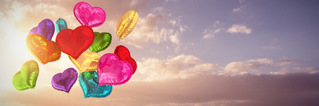 Heart balloons against cloudy sky landscapeの写真素材
