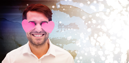 Handsome man with hearts over his eyes against blurred white light の写真素材