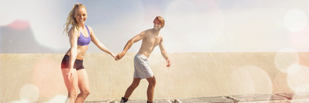 Fit couple rollerblading together on the promenade on a sunny dayの写真素材
