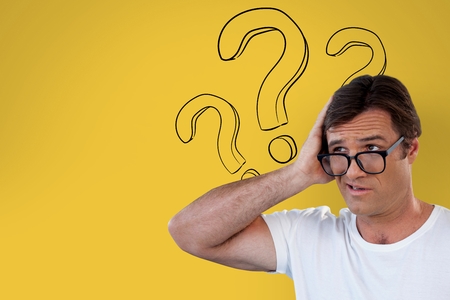 Digital composite of Confused man with glasses holding his head on yellow background with question marksの写真素材